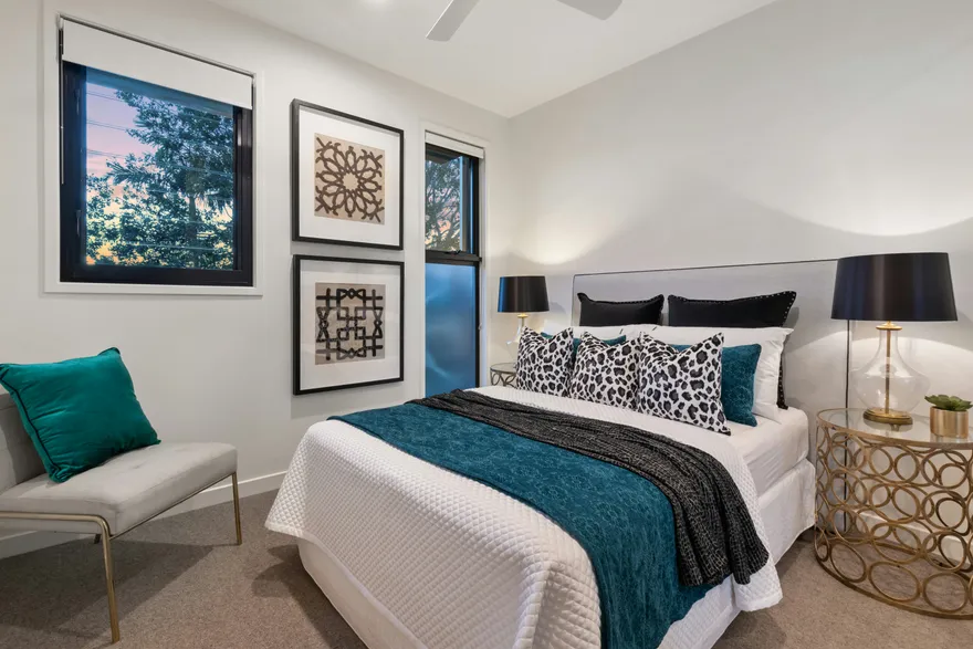 A styled bedroom with built-in storage and framed prints